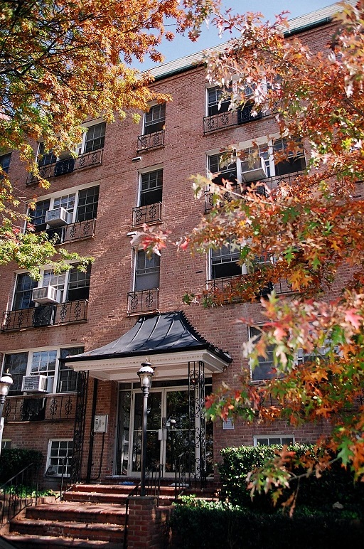 the front of a brick building with trees in front of it